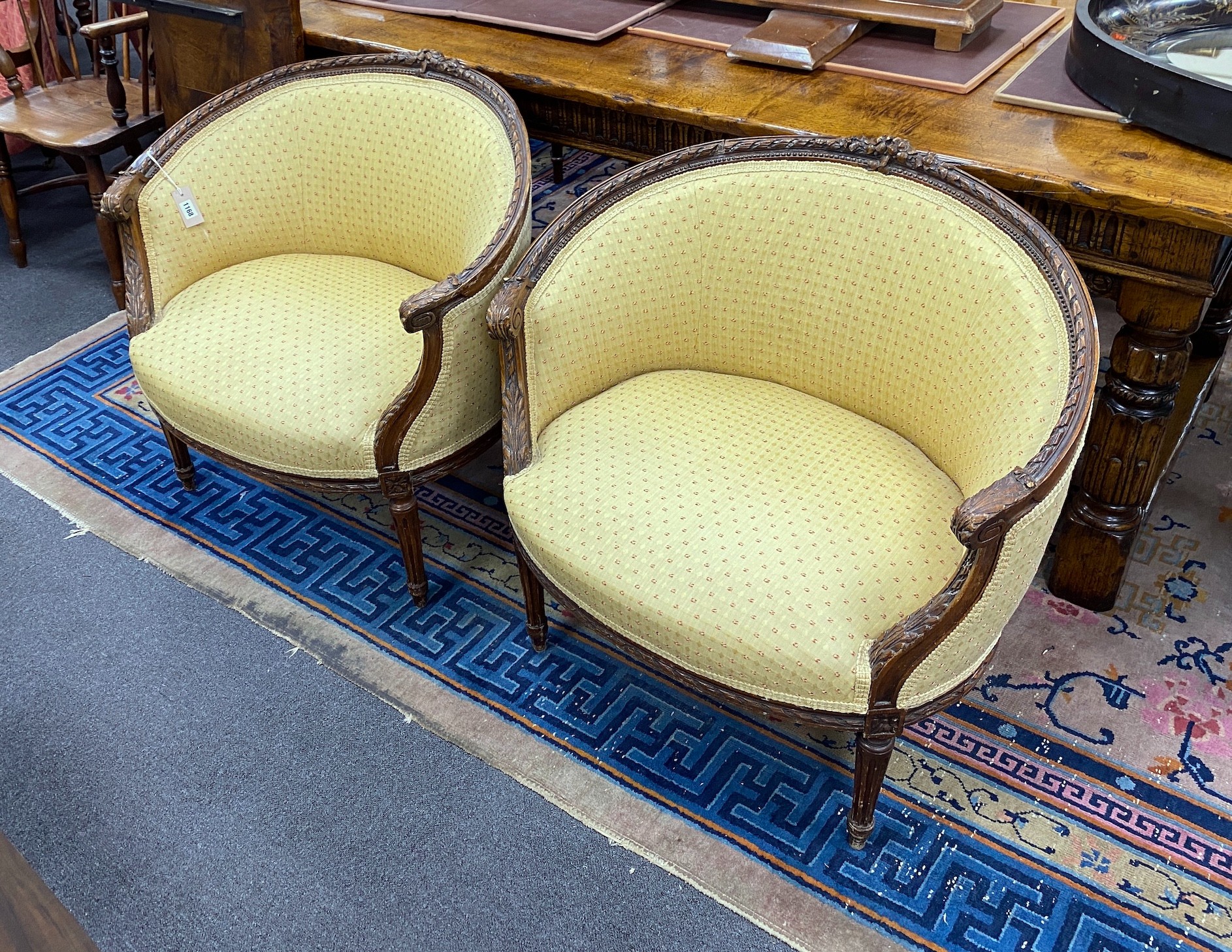 A pair of Louis XVI style carved beech upholstered tub framed chairs, width 82cm, depth 50cm, height 77cm